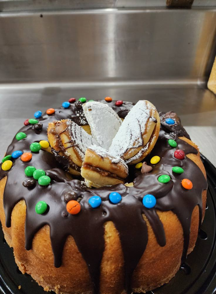 Chocolate-glazed bundt cake with candy-coated chocolates and cookie garnish